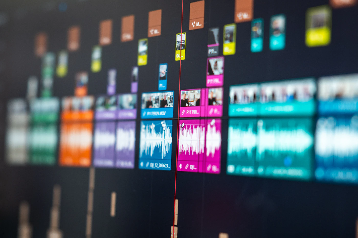 Colorful video editing timeline with audio waveforms and clips