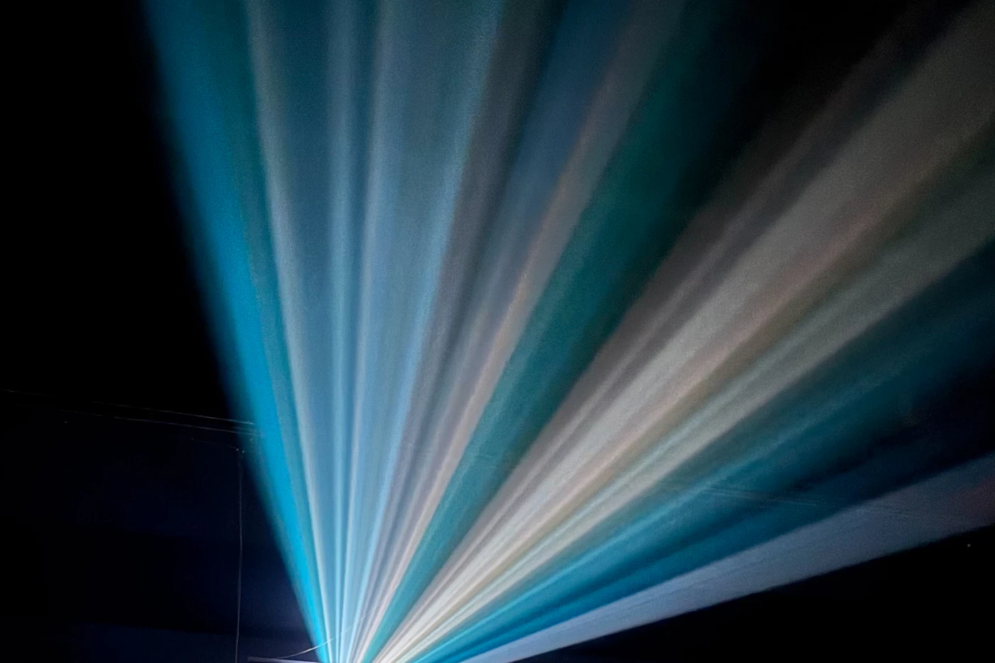 Beams of light from a cinema projector cutting through a dark room
